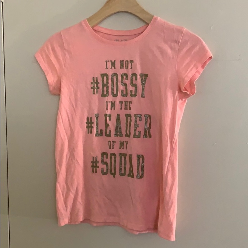 Pink graphic T-shirt with gold words .